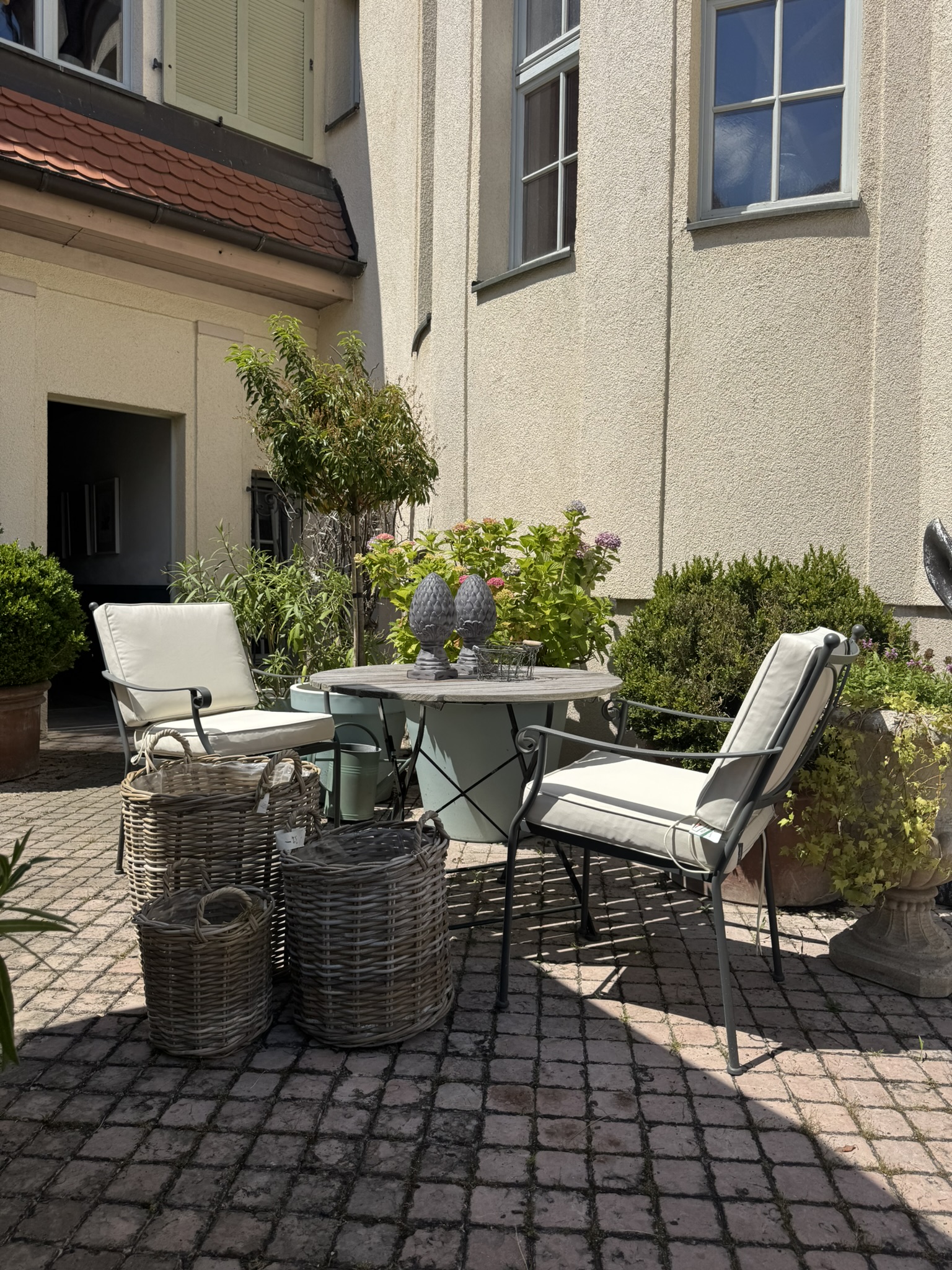 Neptune-Gartenstühle am Bistrotisch im Hof